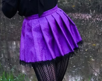 Falda corta plisada de damasco brocado jacquard morado con ribetes de encaje negro
