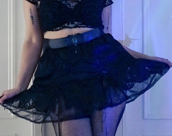 Falda corta alternativa en satén negro con ribete de encaje, cinta de raso y organza.