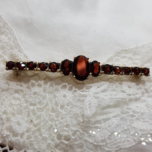 Garnet jewelry, bar brooch with lively garnet stones in 333 yellow gold