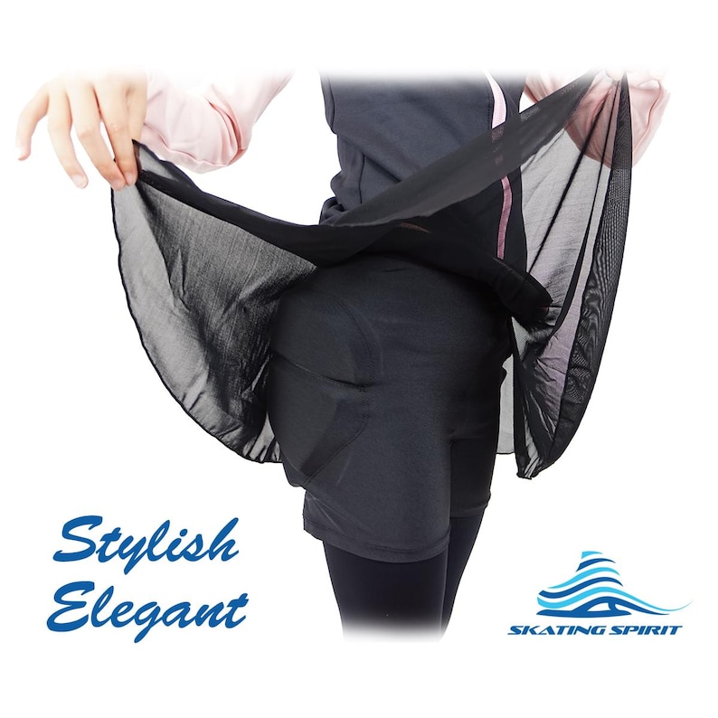 May include: A black sheer skirt worn over black leggings. The skirt is held up by a person's hand. The text "Stylish Elegant" is printed below the skirt. The text "SKATING SPIRIT" is printed below a stylized blue wave logo.