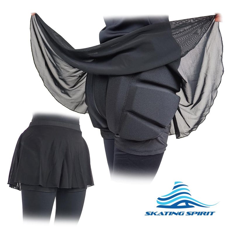 May include: Black figure skating skirt with built-in padded hip protection. The skirt has a sheer overlay and a shorter, fitted underskirt. The logo "SKATING SPIRIT" is visible in the bottom right corner.