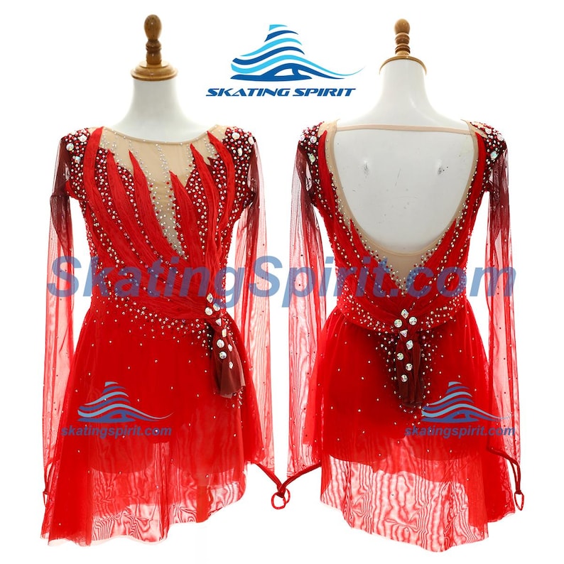Peut inclure: Une robe de patinage artistique rouge &agrave; manches longues avec un d&eacute;collet&eacute; et un dos en maille nude, orn&eacute;e de nombreux cristaux transparents. L'avant pr&eacute;sente un motif en forme de flamme et le dos un d&eacute;collet&eacute; plongeant. Logo Skating Spirit.