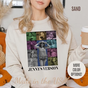 May include: A beige sweatshirt featuring a collage of nine photographs of people. The photos are arranged in a grid pattern and are surrounded by a colourful border. The text "Jenny's Version" is printed below the collage. The text "Made in the USA" is printed below the text "Jenny's Version". The text "SAND" is printed in the top right corner of the image. The text "More Colour Options!" is printed in the bottom right corner of the image.