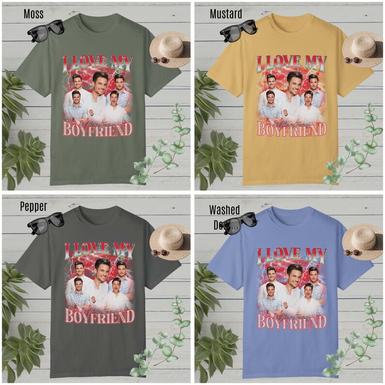 May include: Four different color t-shirts with a graphic print of a group of men with the text "I Love My Boyfriend" in red and white letters. The shirts are displayed on a white wooden background with plants and sunglasses.
