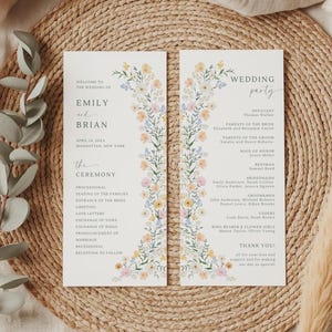 Könnte beinhalten: Zwei vertikale, weiße Hochzeitskarten mit einem Blumenrand aus gelben, rosa und blauen Wildblumen. Die linke Karte zeigt Emily und Brian, den 14. April 20XX, und den Ablauf. Die rechte Karte listet die Hochzeitsgesellschaft und einen Dankestext auf.
