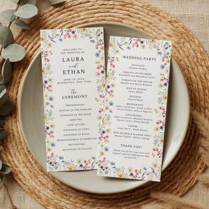 May include: Wedding ceremony programs with floral borders. The programs, for Laura and Ethan's wedding, include the ceremony details and wedding party names. The programs are on a white background with colorful floral accents.