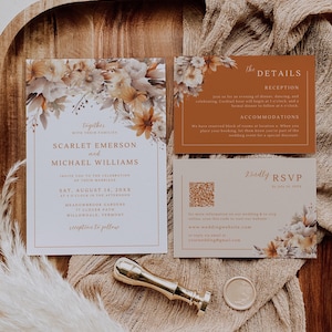May include: Wedding stationery set featuring floral designs in cream and brown tones. The set includes an invitation, details card, and RSVP card. A gold wax seal and stamper are also visible.