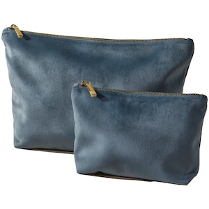 Pu&ograve; includere: Due pochette in velluto blu con cerniera, una pi&ugrave; grande dell'altra, con cerniere dorate.
