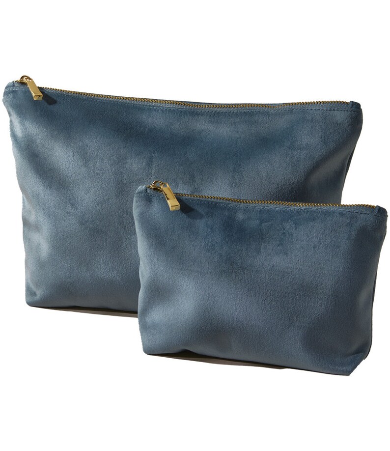 Pu&ograve; includere: Due pochette in velluto blu con cerniera, una pi&ugrave; grande dell'altra, con cerniere dorate.