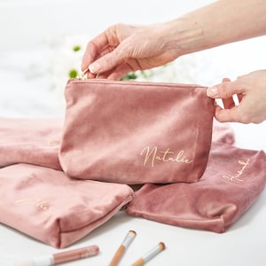Pu&ograve; includere: Quattro pochette in velluto rosa con lettere dorate. Le pochette sono personalizzate con i nomi Natalie, Amelia, Hannah e Jessica.