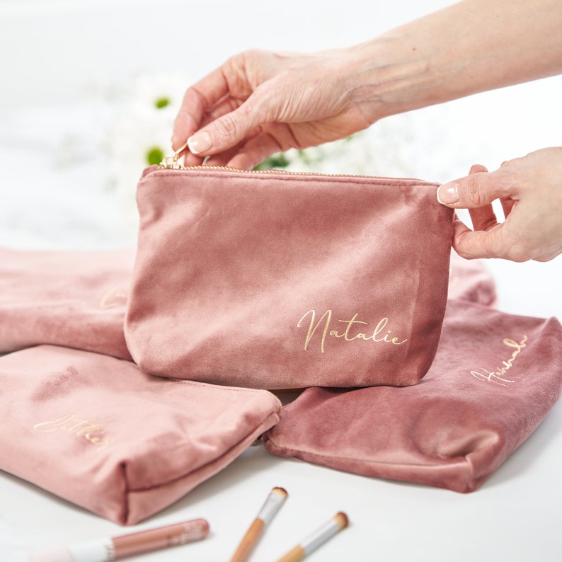 Pu&ograve; includere: Quattro pochette in velluto rosa con lettere dorate. Le pochette sono personalizzate con i nomi Natalie, Amelia, Hannah e Jessica.