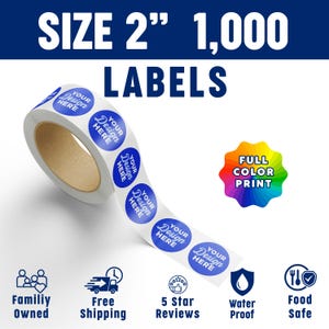 May include: A roll of 1,000 circular labels, each 2 inches in diameter, featuring the text 'YOUR DESIGN HERE' in white on a blue background. The image includes text stating 'SIZE 2" 1,000 LABELS', 'FULL COLOR PRINT', 'Family Owned', 'Free Shipping', '5 Star Reviews', 'Water Proof', and 'Food Safe'.