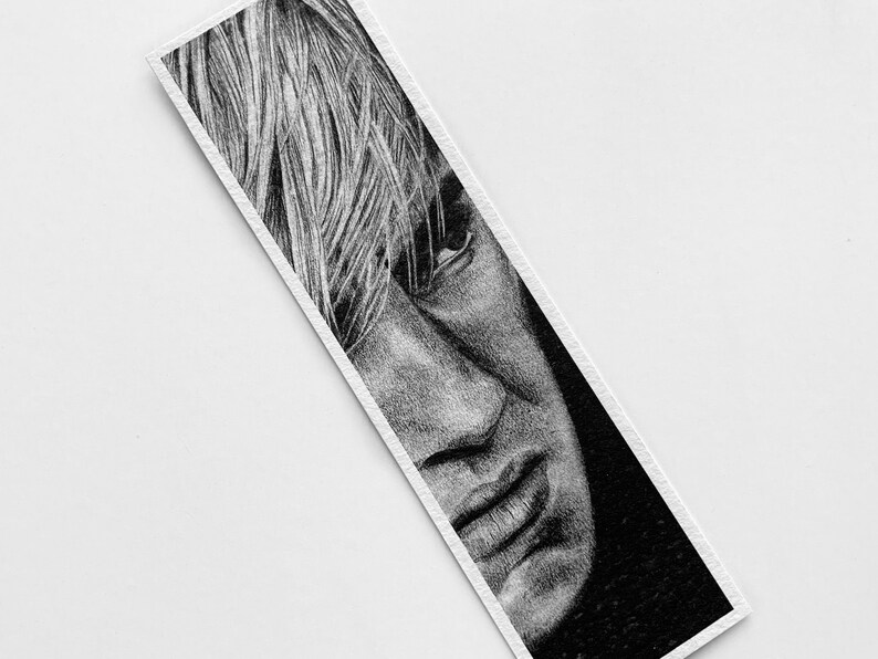 Puede incluir: Dibujo a l&aacute;piz en blanco y negro del rostro de una persona en un marcap&aacute;ginas. El retrato presenta una representaci&oacute;n detallada de la nariz, la boca y el cabello de la persona. El marcap&aacute;ginas es rectangular con borde blanco.