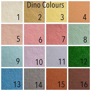 May include: A color chart labeled "Dino Colours" with sixteen squares of felt in various shades. Colors include cream, gold, yellow, peach, pink, rose, coral, mint, teal, lavender, silver, green, blue, gray, rust, and brown.