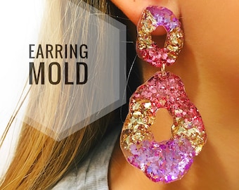 Könnte beinhalten: Ein Paar rosa und goldene Glitzer-Harzohrringe mit einem großen, unregelmäßigen Donut-förmigen Design. Die Ohrringe sind an einem Ohr einer Person zu sehen. "EARRING MOLD" ist in weißer Schrift auf grauem Hintergrund geschrieben.