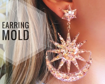 Op de afbeelding: Een paar gouden glitter oorbellen in de vorm van een ster en een halve maan. De oorbellen zijn groot en hangen aan de oorlel. De tekst "EARRING MOLD" is zichtbaar in de afbeelding.