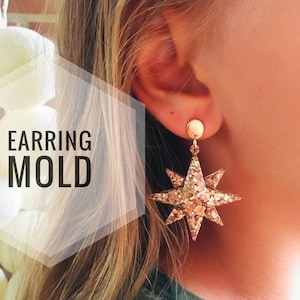 May include: Gold glitter star-shaped earrings. The earrings are hanging from a person's ear. The earrings are a DIY project and the image includes the text "EARRING MOLD".