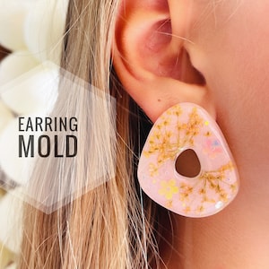 May include: A pair of pink resin earrings with a floral design and a hole in the centre. The earrings are made with pressed flowers and glitter. "EARRING MOLD" is written in white text on a white background.
