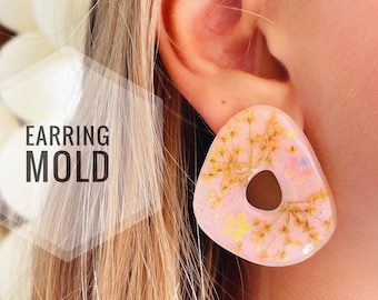 Könnte beinhalten: Ein Paar rosa Harzohrringe mit einem Blumendesign und einem Loch in der Mitte. Die Ohrringe sind aus gepressten Blumen und Glitzer gefertigt. "EARRING MOLD" ist in weißer Schrift auf weißem Hintergrund geschrieben.