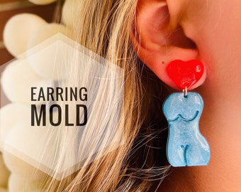 May include: A pair of earrings, one is a red heart and the other is a blue body shape. The earrings are made of resin and are hanging from a person's ear. The text "EARRING MOLD" is visible in the image.