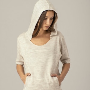 以下が含まれることがあります： 薄いグレーのフード付きスウェットシャツ。丸首とポケットが2つ付いています。柔らかく快適な生地で作られています。