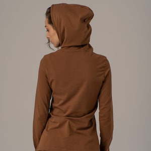 May include: A brown long-sleeved shirt with a hood. The shirt is made of a soft, comfortable material.