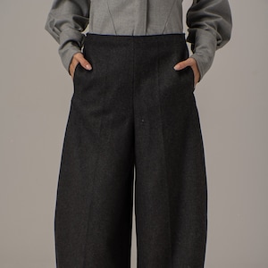 May include: Dark gray wide-leg pants with a high waist and pockets. The pants are made of a thick, textured fabric.