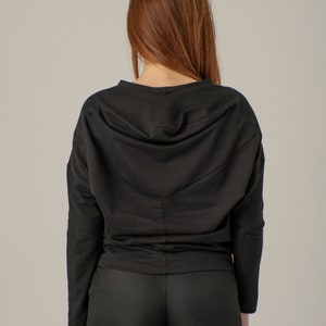 May include: A black long-sleeved top with a gathered neckline and matching black pants. The top has a relaxed fit and the pants have a straight leg.