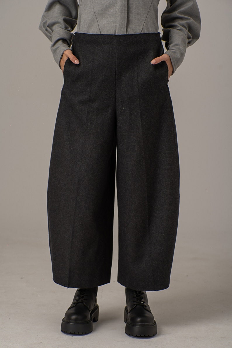 May include: Dark gray wide-leg pants with a high waist and pockets. The pants are made of a thick, textured fabric.