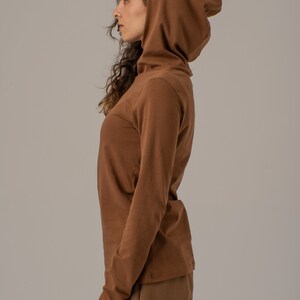 May include: A brown long-sleeved shirt with a turtleneck and a matching brown hooded top.