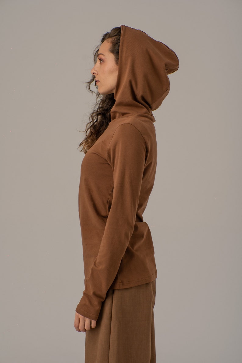 May include: A brown long-sleeved shirt with a turtleneck and a matching brown hooded top.