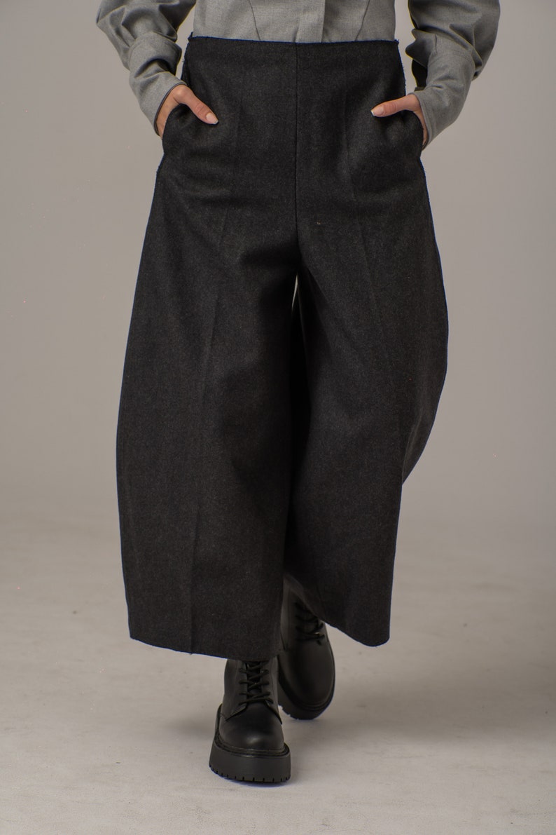 May include: Black wide-leg pants with a high waist and a relaxed fit. The pants are made of a thick, textured fabric.