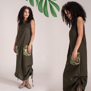 May include: A long, olive green sleeveless dress with a drawstring at the bottom. The dress has two large pockets on the front, each with a camouflage print.