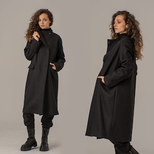 May include: Two women wearing long black coats with a single button closure. The coats have a relaxed fit and are made of a soft, comfortable fabric.
