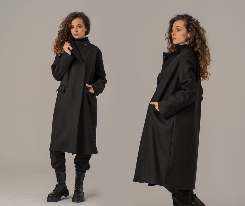 May include: Two women wearing long black coats with a single button closure. The coats have a relaxed fit and are made of a soft, comfortable fabric.