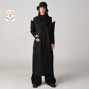 May include: A black long coat with a belt and a black hat. The coat has a long, flowing silhouette and a classic design.