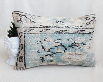 May include: A light blue and white patterned throw pillow with a black and white geometric design. The pillow is made of a soft, woven fabric and has a rectangular shape.