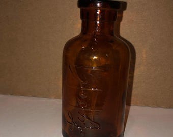 Botella vacía de vidrio ámbar de Lysol de la década de 1920 con la inscripción Lysol en relieve.