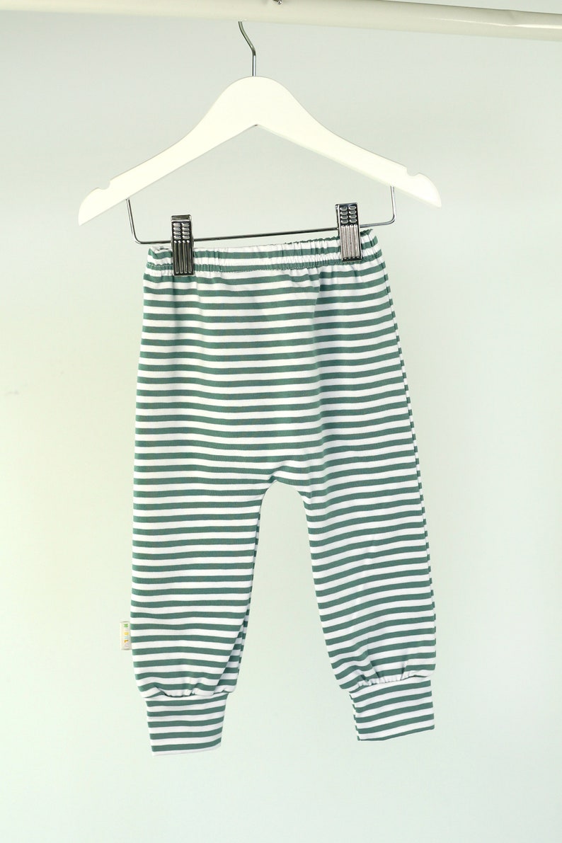 May include: Green and white striped baby leggings with a cuffed bottom.