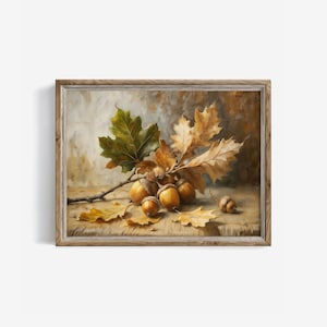 Puede incluir: Pintura enmarcada de naturaleza muerta con una rama de hojas de roble verdes y marrones y varias bellotas. La pintura tiene una paleta de colores cálidos con tonos de marrón, amarillo y verde, evocando un tema otoñal.