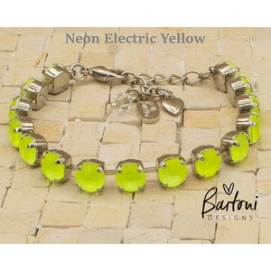 May include: A silver-toned bracelet featuring round, neon electric yellow stones set in metal prongs. The bracelet includes a lobster clasp, an adjustable chain, a small heart charm, and a tag with the text Bartoni DESIGNS. Neon Electric Yellow.