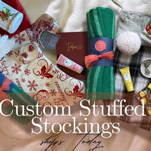 May include: An assortment of Christmas-themed gifts, including a red stocking, green striped towels, candles, lotions, and a 2025 planner. The image features the text "Custom Stuffed Stockings" in a festive arrangement.