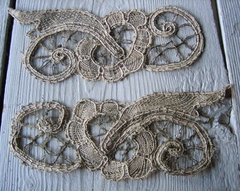 May include: Two delicate, gold-colored lace appliques with intricate floral designs. The lace is woven in a fine, openwork pattern, creating a delicate and airy effect.