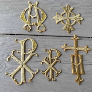 May include: Five gold embroidered religious symbols, including a Chi Rho, a cross, and the Greek letters Alpha and Omega.
