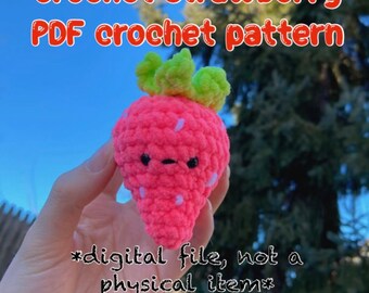 Puede incluir: Una fresa de crochet rosa con un tallo y hojas de crochet verde. La fresa tiene una cara linda con ojos negros y una boca negra. El texto "*archivo digital, no un artículo físico*" está escrito debajo de la fresa.