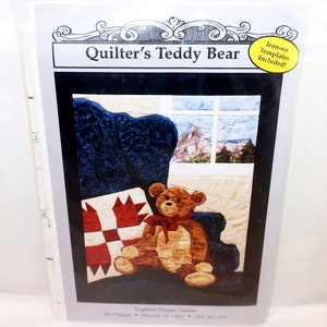 May include: A package for a quilting project titled "Quilter's Teddy Bear." The image on the package shows a teddy bear sitting in a blue chair with a red and white quilt. The package includes iron-on templates.