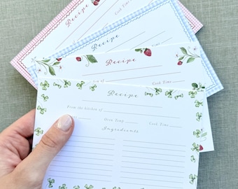 Peut inclure: Un ensemble de quatre fiches de recettes rectangulaires à fond blanc avec des bordures décoratives variées. La fiche supérieure présente un motif de trèfles verts, tandis que les autres affichent des fraises, des cerises et des motifs vichy.