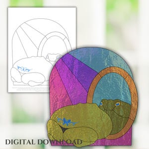 May include: A stained glass design featuring a frog sitting in a round window with a purple, pink, and blue background. The frog is green with blue eyes and a butterfly design on its back.