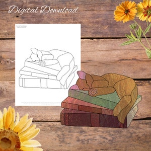 May include: A stained glass design of a cat sleeping on a stack of books. The cat is brown and orange and the books are various shades of brown and green. The design is outlined in black.
