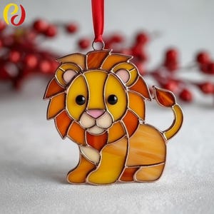 May include: A stained glass lion decoration with a red ribbon. The lion has a yellow body, orange mane, and a pink nose. The ornament is made of multiple glass pieces, suitable for hanging.